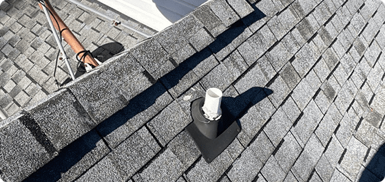 Plumbing vent pipe with flashing on shingled roof