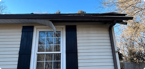 Damaged vinyl siding and gutters on residential house exterior