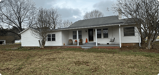 White single-story home with porch on grassy lot